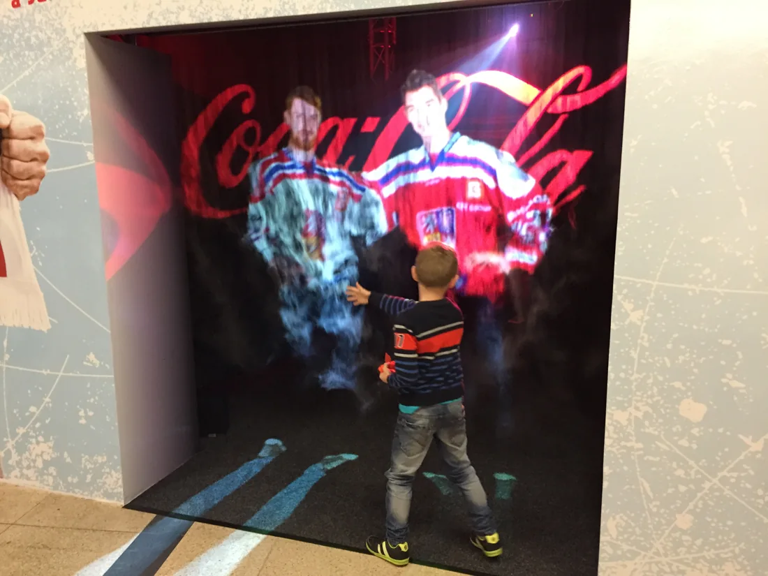Dítě objevuje mlžnou projekci Coca-Cola.