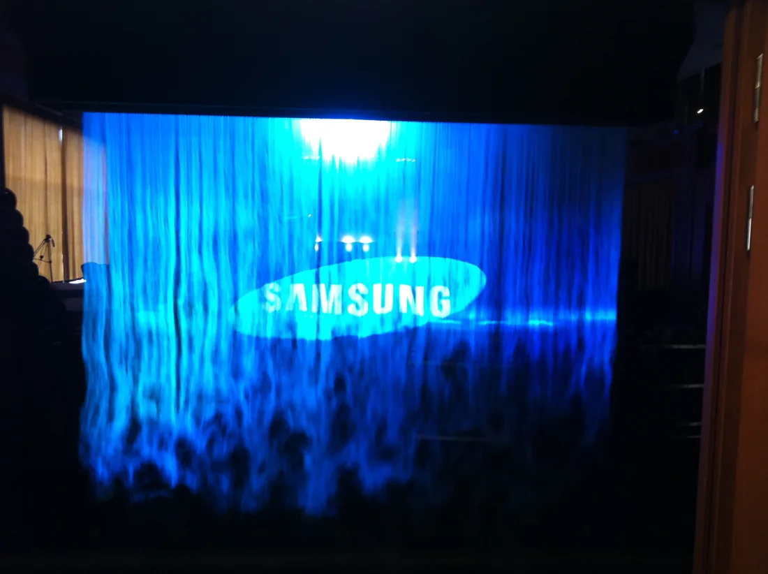 Logo Samsung promítané na modrou mlžnou plochu.