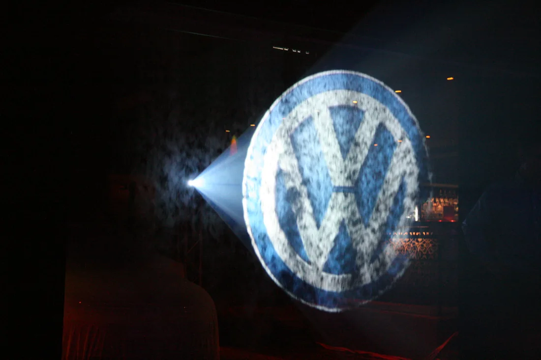 Znak Volkswagen na modrobílé mlžné ploše.